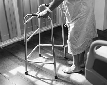 An elderly person using a walker.